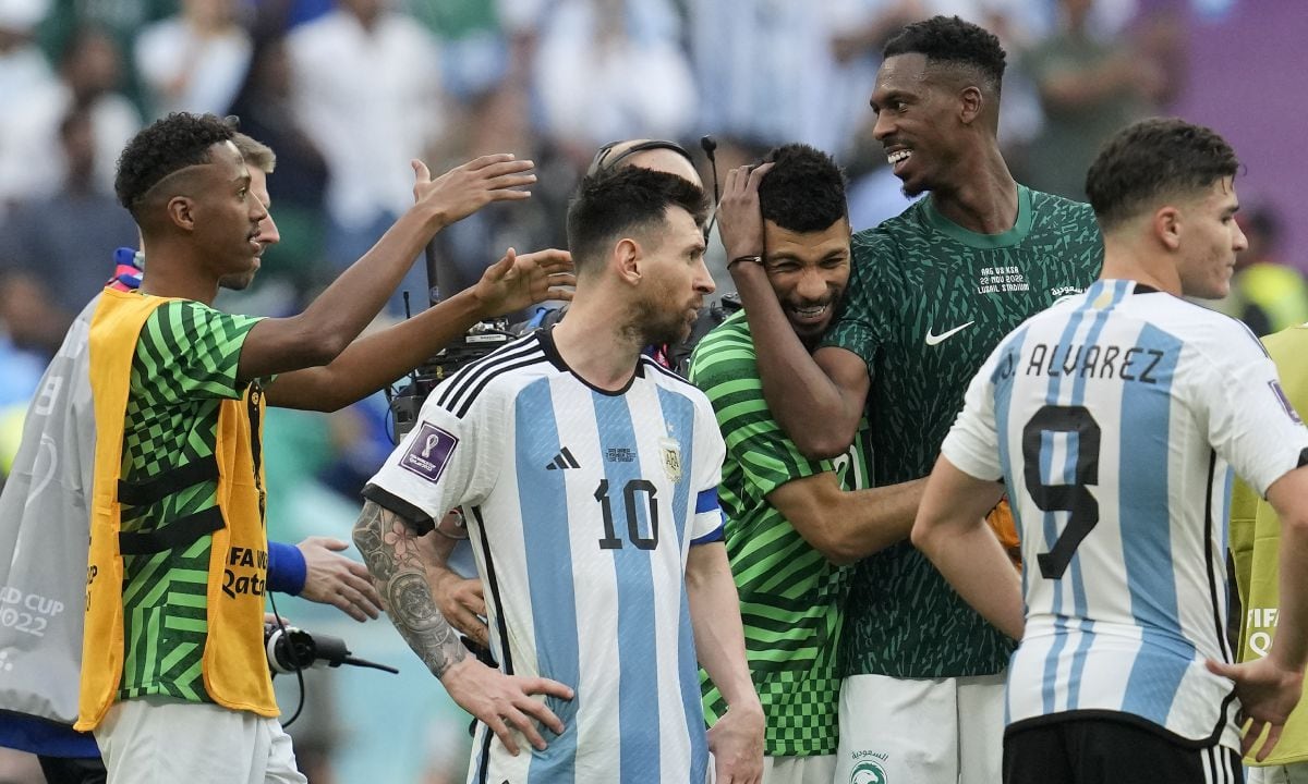 Argentina's Lionel Messi standing beside Saudi Arabia's players celebrating after winning the World Cup group C soccer match between Argentina and Saudi Arabia at the Lusail Stadium in Lusail, Qatar, Tuesday, Nov. 22, 2022. (AP/Natacha Pisarenko)
