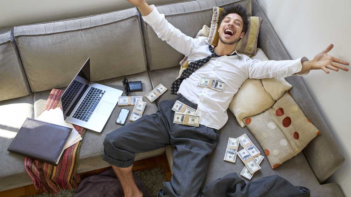 man bursting with joy with lots of money