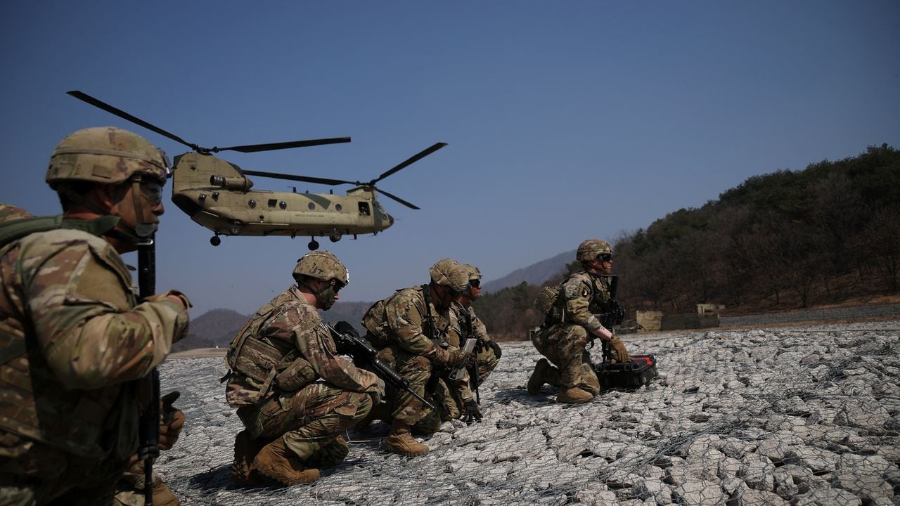 Los soldados estadounidenses soportan fuertes vientos mientras un Chinook CH-47 del Ejército de EE. UU. se prepara para aterrizar durante un ejercicio militar que forma parte del ejercicio militar conjunto Freedom Shield entre Corea del Sur y EE. UU