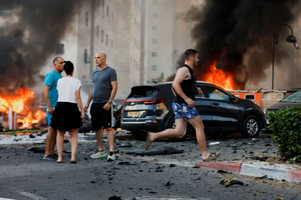La gente reacciona en la carretera, tras los ataques con cohetes lanzados desde Gaza, en Ashkelon, Israel, el 7 de octubre de 2023. REUTERS/Amir Cohen