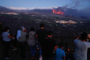 La gente observa cómo fluye la lava después de la erupción de un volcán en la isla canaria de La Palma, visto desde Tijarafe, España, 29 de septiembre de 2021. Foto REUTERS / Borja Suarez