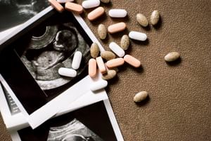 Foto del feto en una ecografía y unas pastillas sobre fondo marrón. Bebé esperando. La ecografía da como resultado el segundo trimestre del embarazo. Vitaminas y nutrición adecuada para una mujer embarazada. Tratamiento de infertilidad. Inseminación artificial. Tener un bebé con FIV.