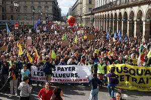 Los manifestantes pasan por el museo del Louvre en la Rue de Rivoli durante una manifestación como parte del 12º día de huelgas y protestas nacionales contra la reforma de las pensiones del gobierno francés