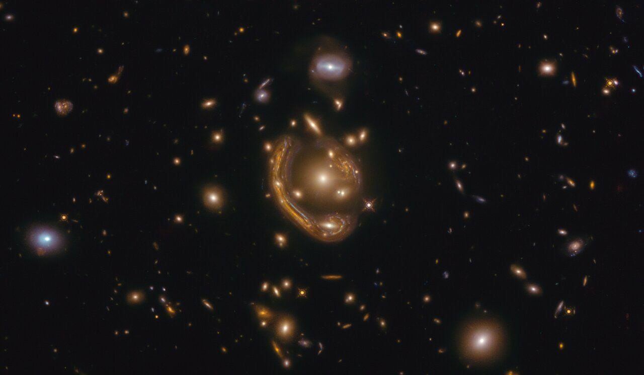 Imagen que muestra como pareciera que una galaxia se curva, a causa el fenómeno llamado 'lente gravitacional'.