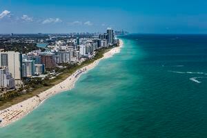 Aerial view of South Beach Miami Florida cityscape with buildings along the beach on a beautiful sunny day, people on beach and ocean