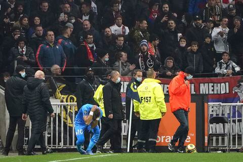 Dimitri Payet del Marsella cae al suelo tras ser agredido por un proyectil lanzado desde la grada durante el partido contra Lyon por la liga francesa