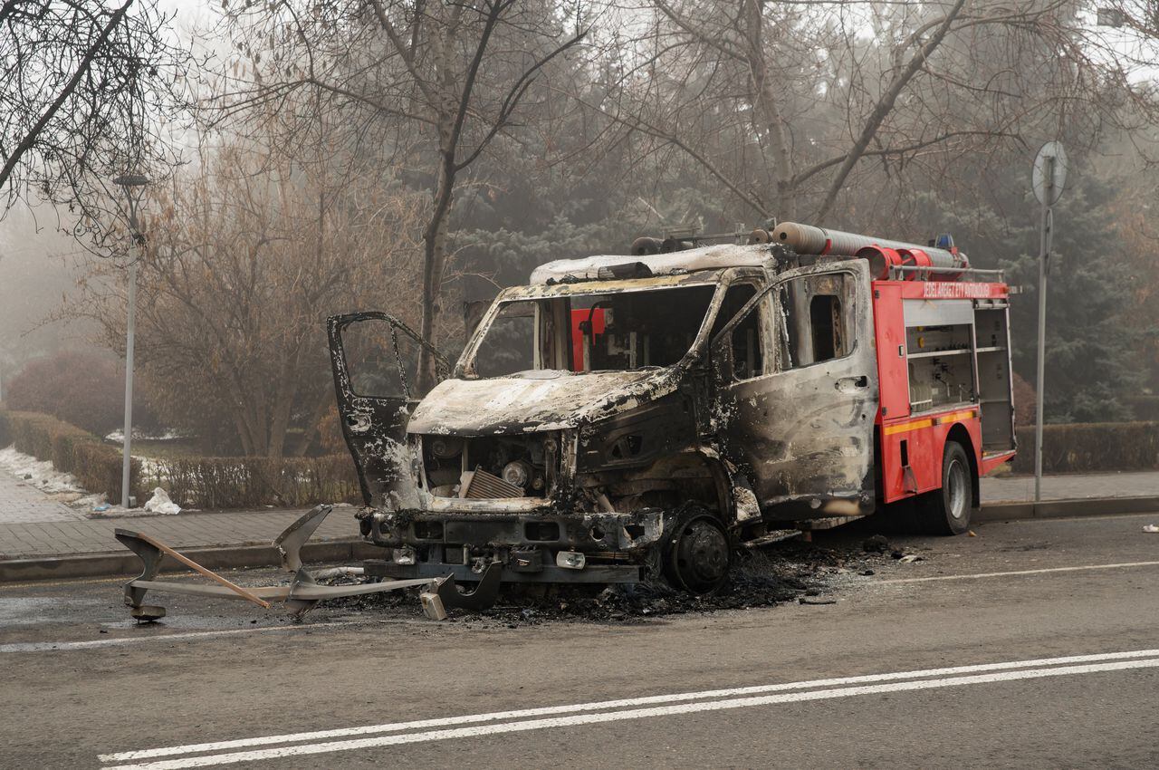 Una imagen muestra un camión de bomberos quemado en una calle en el centro de Almaty el 6 de enero de 2022, luego de la violencia que estalló luego de las protestas por los aumentos en los precios del combustible. - Las bajas entre los oficiales de seguridad kazajos el 6 de enero aumentaron a 18 muertos y 748 heridos mientras las autoridades buscaban sofocar los disturbios en el ex país soviético