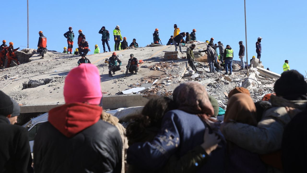 La gente observa cómo los rescatistas y los civiles buscan sobrevivientes bajo los escombros de los edificios derrumbados en Nurdagi, en el campo de Gaziantep, el 9 de febrero de 2023, tres días después de un terremoto mortal que azotó Turquía y Siria.(Photo by Zein Al RIFAI / AFP)