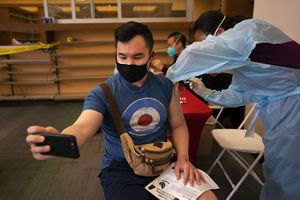 Fotografía de archivo del 12 de abril de 2021 de Freeson Wong, de 31 años, tomándose una selfie mientras recibe una dosis de la vacuna de Moderna contra el coronavirus en el barrio Chinatown de Los Ángeles. (AP Foto/Jae C. Hong, Archivo)