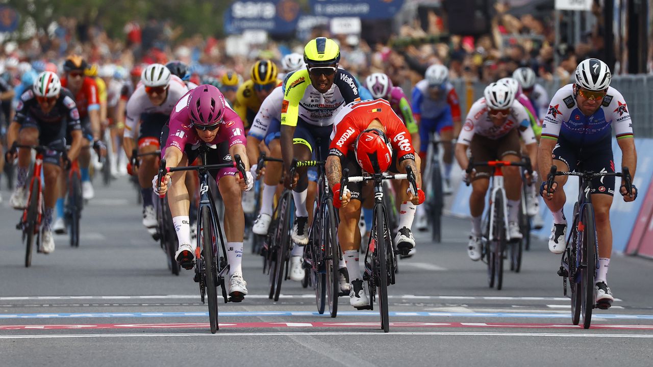 Team Groupama-FDJ's French rider Arnaud Demare (L) crosses the finish line to win ahead of Team Lotto's Australian rider Caleb Ewan (C) the 6th stage of the Giro d'Italia 2022 cycling race, 192 kilometers between Palmi and Scalea, Calabria, on May 12, 2022. (Photo by Luca Bettini / AFP)
