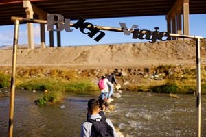 Se ve un letrero que dice "Que tengas un buen viaje" mientras los migrantes cruzan el río Bravo para entregarse a los agentes de la Patrulla Fronteriza de los EE. UU. para solicitar asilo en El Paso, Texas, EE. UU., visto desde Ciudad Juárez, México, el 13 de diciembre de 2022. 