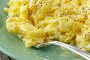 Natural light photo of farm fresh scrambled eggs on green glass plate with antique silver plated forkPlease view more rustic food images here: