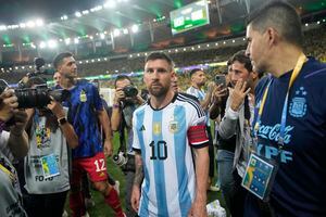 El delantero argentino Lionel Messi se marcha de la cancha tras una riña entre hinchas, previa al partido de la eliminatoria mundialista ante Brasil en el Maracaná, el martes 21 de noviembre de 2023. (AP Foto/Silvia Izquierdo)