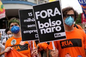 Un manifestante sostiene el mensaje portugués "Fuera ahora Bolsonaro" durante una protesta contra el manejo del presidente brasileño Jair Bolsonaro de la pandemia de COVID-19, la economía y la corrupción, en el Día de la Independencia en Río de Janeiro, Brasil, el martes, sept. 7, 2021. (AP Photo/Silvia Izquierdo)