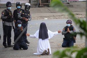 This handout photo taken on March 8, 2021 and released on March 9 by the Myitkyina News Journal shows a nun pleading with police not to harm protesters in Myitkyina in Myanmar's Kachin state, amid a crackdown on demonstrations against the military coup. (Photo by Handout / Myitkyina News Journal / AFP) / RESTRICTED TO EDITORIAL USE - MANDATORY CREDIT "AFP PHOTO / Myitkyina News Journal " - NO MARKETING - NO ADVERTISING CAMPAIGNS - DISTRIBUTED AS A SERVICE TO CLIENTS