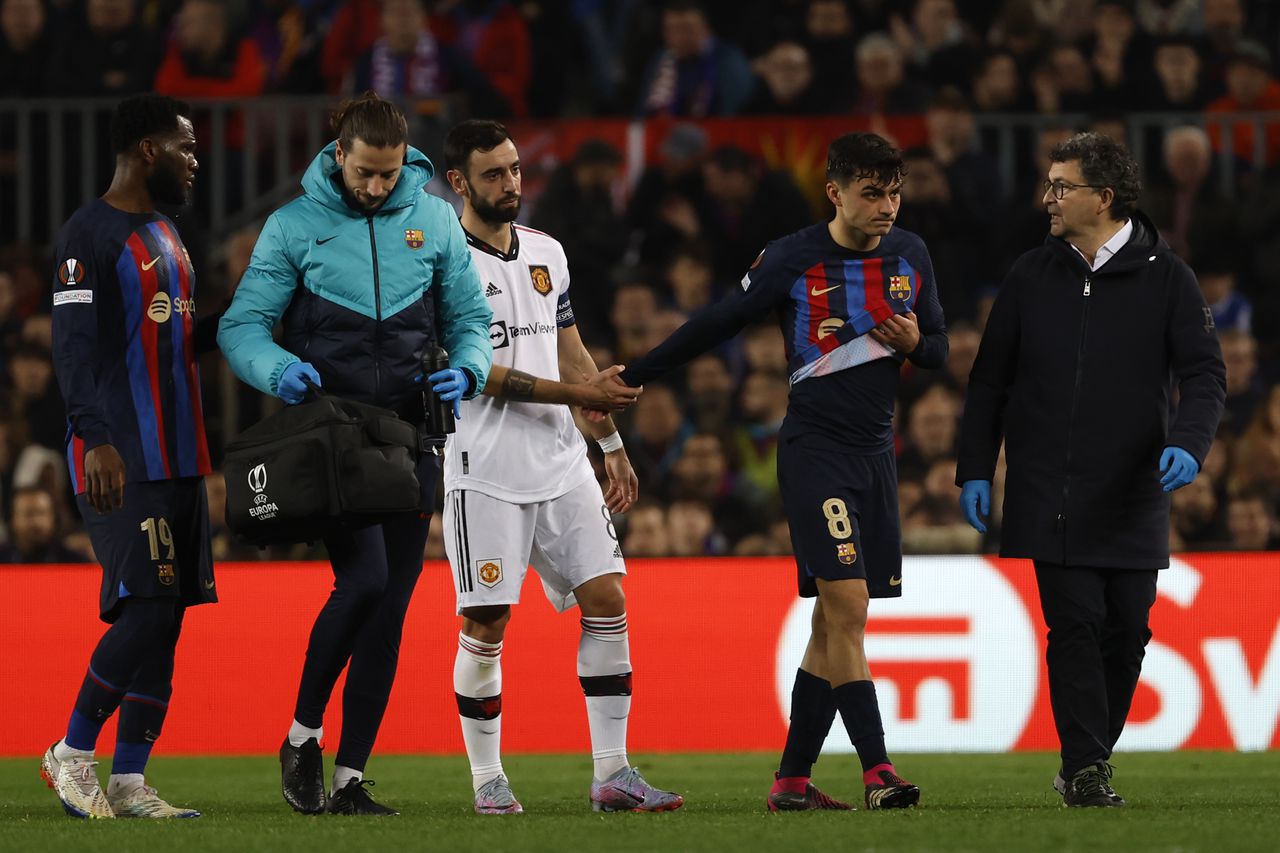 Manchester United's Bruno Fernandes, center, comforts Barcelona's Pedri, second right, as he walks off the pitch while he is substituted by Barcelona's Sergi Roberto after being injured during the Europa League playoff first leg soccer match between Barcelona and Manchester United at the Camp Nou stadium in Barcelona, Spain, Thursday, Feb. 16, 2023. (AP Photo/Joan Monfort)