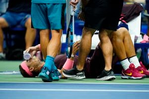 Rafael Nadal sostiene una botella en su rostro al recibir tratamiento durante el partido contra Fabio Fognini.