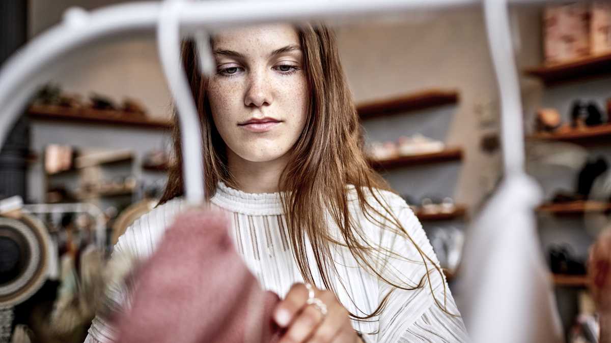 Mujer en un armario organizando su ropa