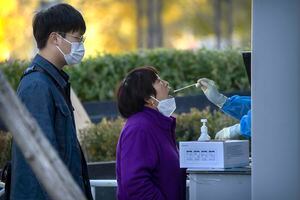 A una mujer le toman una muestra de la garganta para una prueba de COVID-19 en un sitio de pruebas de coronavirus en Beijing, el viernes 4 de noviembre de 2022. 
