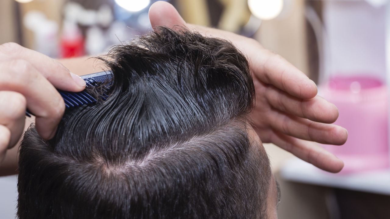 Peinado y cuidado del cabello para hombres con la ayuda de una máquina de tijeras y corte de cabello en la peluquería.