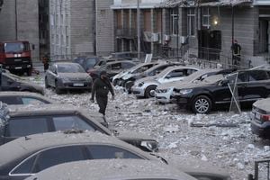 Un agente de policía camina por un estacionamiento con autos dañados, frente a un edificio de varias plantas, luego de un ataque ruso sobre Kiev, en Ucrania, el 30 de mayo de 2023. (AP Foto/Roman Hrytsyna)