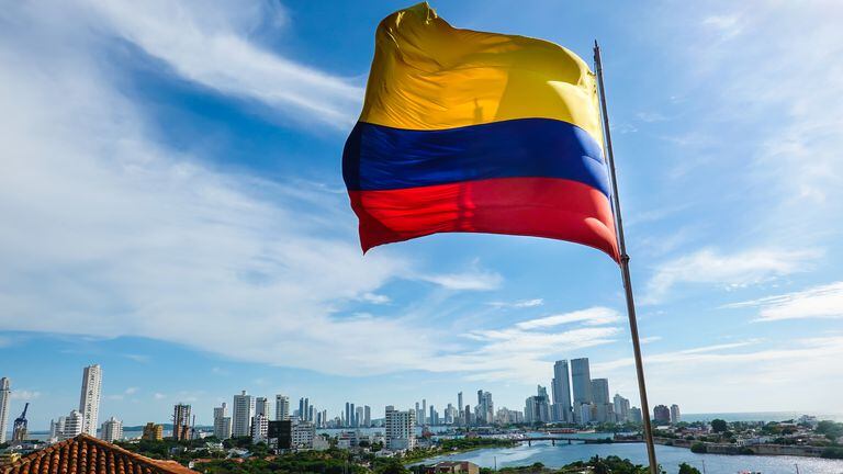 The Colombian flag on a beautiful blue sky