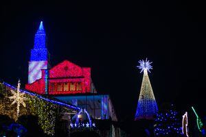 La gente disfruta de las luces navideñas de la emblemática iglesia de Monserrate en Bogotá, Colombia, el 3 de diciembre de 2022. Las decoraciones navideñas tienen como objetivo mostrar la biodiversidad de Colombia. (Foto de Sebastián Barros/NurPhoto vía Getty Images)