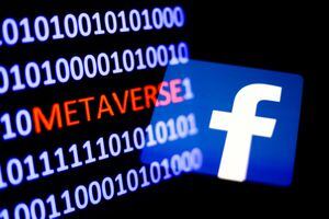 A binary code with the word 'metaverse' displayed on a laptop screen and Facebook logo displayed on a phone screen are seen in this multiple exposure illustration photo taken in Krakow, Poland on October 25, 2021. (Photo by Jakub Porzycki/NurPhoto via Getty Images)