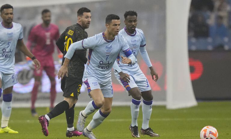 Cristiano Ronaldo, right, playing for a combined XI of Saudi Arabian teams Al Nassr and Al Hilal is challenged by PSG's Lionel Messi during a friendly soccer match, at the King Saud University Stadium, in Riyadh, Saudi Arabia, Thursday, Jan. 19, 2023. (AP/Hussein Malla)
