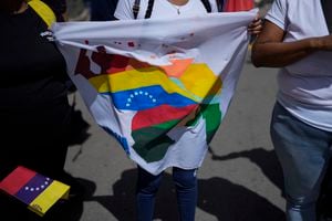Una mujer sostiene una bandera durante un ensayo para el referéndum de diciembre sobre una disputa territorial entre Guayana y Venezuela, en Caracas, Venezuela, el 19 de noviembre de 2023. (AP Foto/Ariana Cubillos)