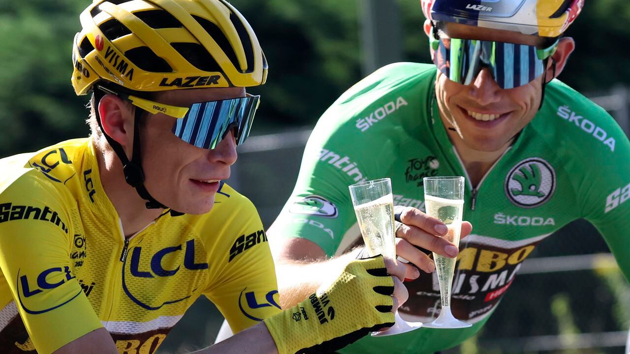 Denmark's Jonas Vingegaard, wearing the overall leader's yellow jersey, toasts champagne with teammates Belgium's Wout Van Aert, wearing the best sprinter's green jersey during the twenty-first stage of the Tour de France cycling race over 116 kilometers (72 miles) with start in Paris la Defense Arena and finish on the Champs Elysees in Paris, France, Sunday, July 24, 2022. (Thomas Samson/Pool Photo via AP)
