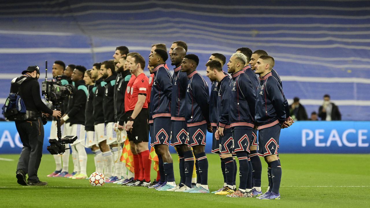 Both teams' players line up before the UEFA Champions League round of 16 second league football match between Real Madrid CF and Paris Saint-Germain at the Santiago Bernabeu stadium in Madrid on March 9, 2022. (Photo by JAVIER SORIANO / AFP)