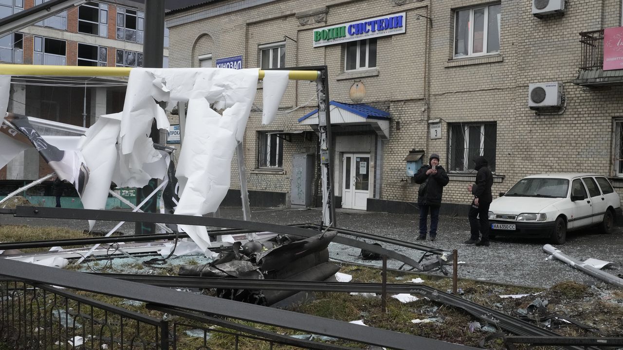 Una mujer toma una foto de las consecuencias de los bombardeos rusos en Kiev, Ucrania, el 24 de febrero del 2022.