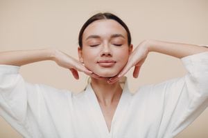 Young woman doing face building facial gymnastics self massage
