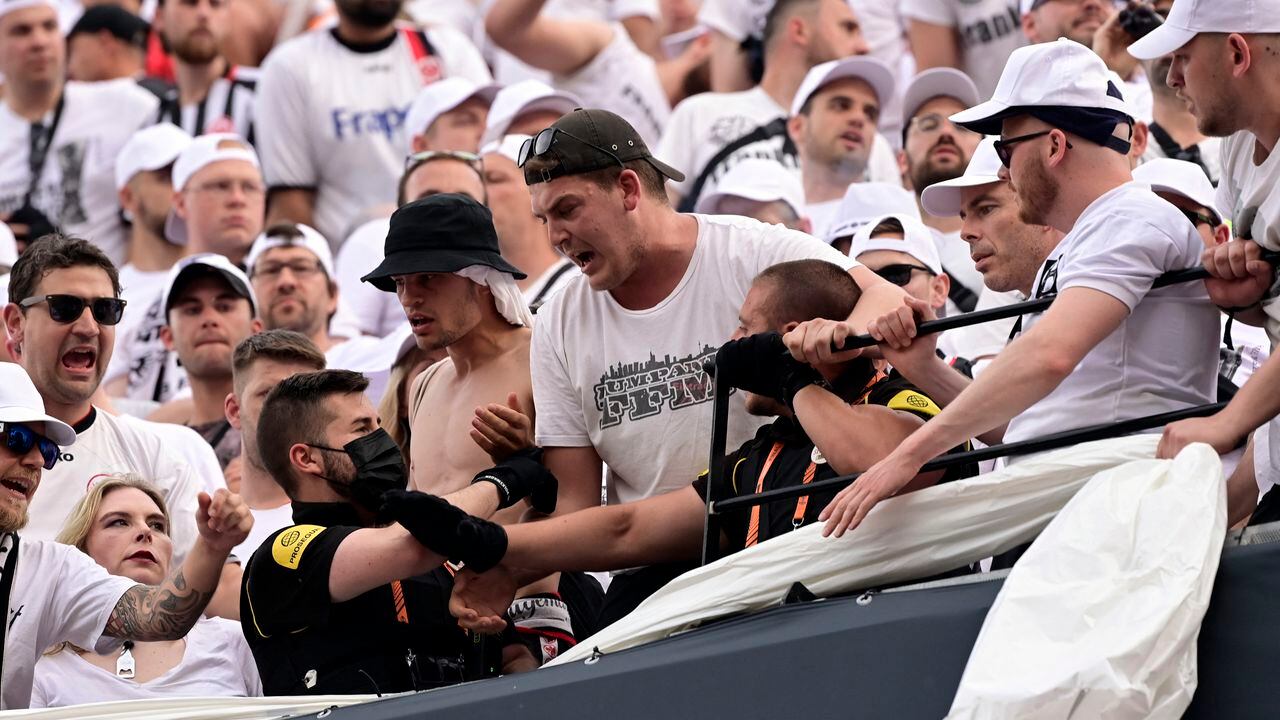Security staff members talk to Frankfurt's supporters prior to the UEFA Europa League final football match between Eintracht Frankfurt and Glasgow Rangers at the Ramon Sanchez Pizjuan stadium in Seville on May 18, 2022. (Photo by JAVIER SORIANO / AFP)