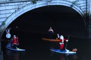 Practicantes de remo vestidos como Papá Noel remar por el río Liffey para alegrar la Navidad contra la enfermedad del coronavirus (COVID-19), en el centro de la ciudad de Dublín, Irlanda. Foto REUTERS / Clodagh Kilcoyne