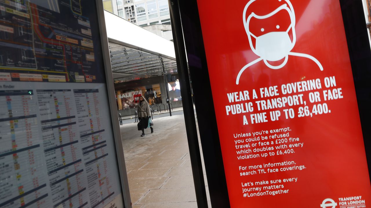 Una pantalla digital en una parada de autobús les dice a los pasajeros que es obligatorio usar una máscara para evitar la propagación del COVID-19 en el transporte público en Londres, el martes 26 de enero de 2021.