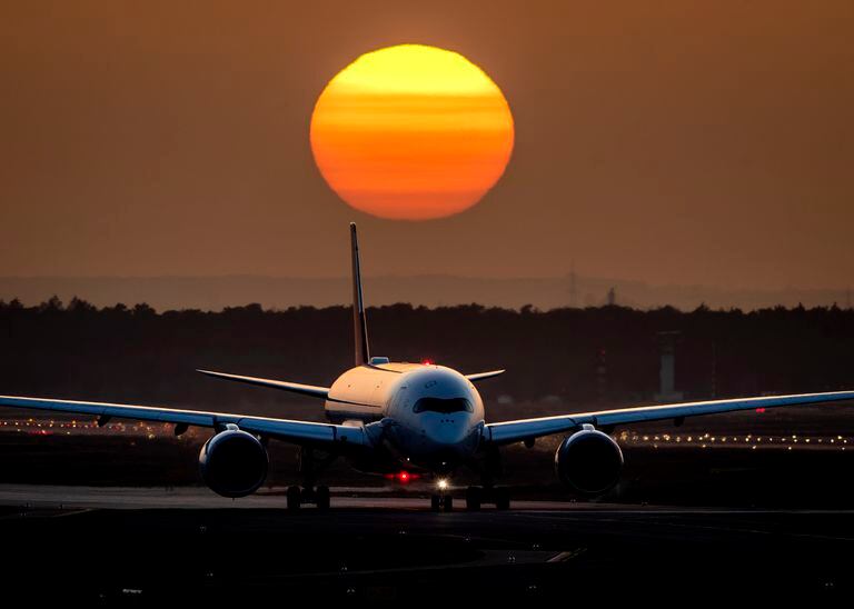 Un avión llega al aeropuerto de Frankfurt, Alemania, mientras se pone el sol. (AP Photo / Michael Probst).