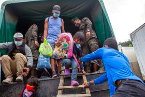 A Honduran migrant child is helped off a Guatemalan army truck after being returned to El Florido, Guatemala, one of the border points between Guatemala and Honduras, Tuesday, Jan. 19, 2021. A once large caravan of Honduran migrants that pushed its way into Guatemala last week had dissipated by Tuesday in the face of Guatemalan security forces. (AP Photo/Oliver de Ros)