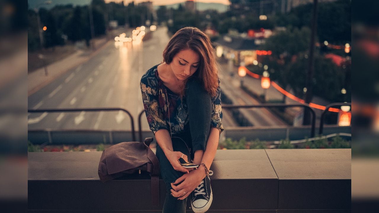 Foto de referencia de una mujer observando el celular