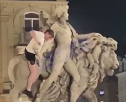 Turista Irlandés aparentemente ebrio escala estatua en Bruselas.