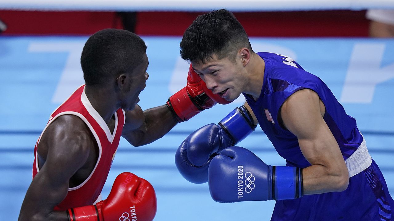 Colombia's Yuberjen Herney Martinez Rivas, right, exchanges punches with Japan's Ryomei Tanaka in their men's flyweight 52-kg quarterfinal boxing match at the 2020 Summer Olympics, Tuesday, Aug. 3, 2021, in Tokyo, Japan. (AP Photo/Themba Hadebe)