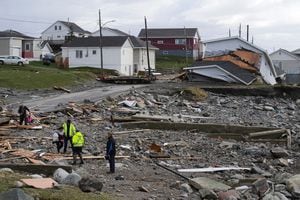 Los funcionarios de la ciudad hablan con una señora, cuya casa fue destruida después del huracán Fiona en Port Aux Basques, Newfoundland, Canadá, el 25 de septiembre de 2022. 