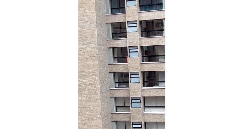 Mujer arriesga su vida desde un piso doce de Medellín al limpiar las ventanas.