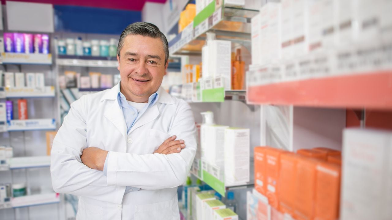 Portrait of a happy man working at the drugstore and looking at the camera smiling