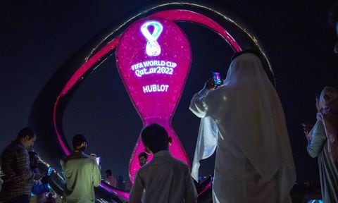 People take photos with the official FIFA World Cup Countdown Clock on Doha's corniche, in Qatar, Friday, Oct. 14, 2022. (AP Photo/Nariman El-Mofty)