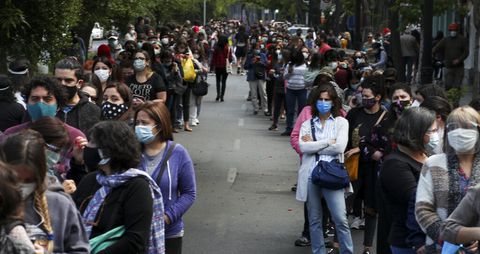 La gente hace fila y espera su turno para votar durante un plebiscito que decidirá si el país sudamericano reemplaza su constitución de 40 años, en Santiago de Chile, el domingo 25 de octubre de 2020 (AP Foto/Esteban Félix).