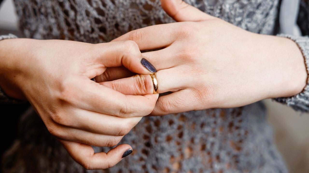 Una mujer se quita un anillo de compromiso, conflicto familiar, primer plano
