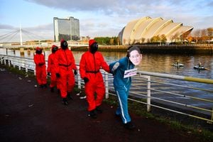 Activistas climáticos vestidos como personajes inspirados en la serie de Netflix "Squid Game" protestan mientras le piden a Samsung que utilice energía 100% renovable, frente a la sede de la Conferencia de las Naciones Unidas sobre el Cambio Climático (COP26) en Glasgow, Escocia, Gran Bretaña, 10 de noviembre de 2021.  Foto REUTERS / Dylan Martinez 