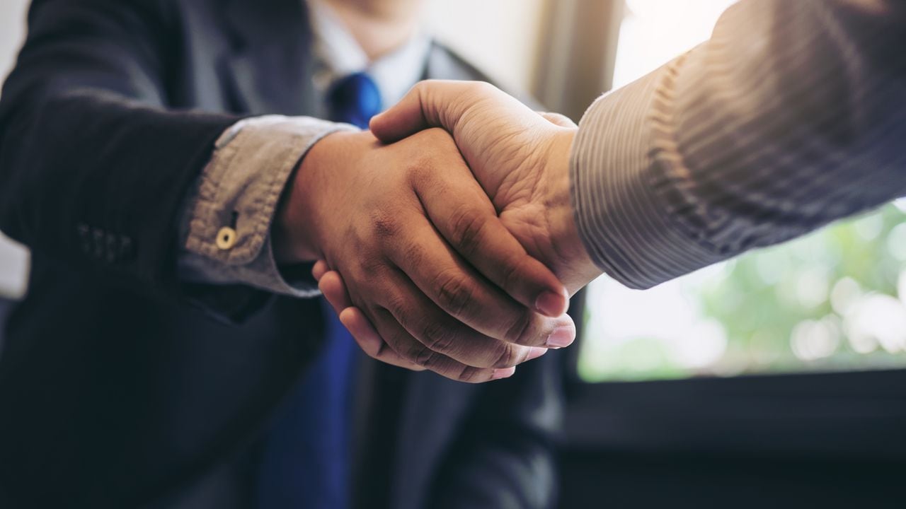 Dos hombres de negocios dándose la mano durante una reunión para firmar un acuerdo y convertirse en un socio comercial, empresas, empresas, confianza, éxito en el trato, contrato entre sus empresas.